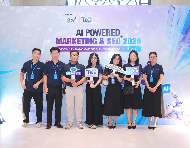 Đội ngũ tổ chức sự kiện AI Powered Marketing & SEO 2026 cầm biển The AI Growth trước backdrop, ngày 22/08/2026